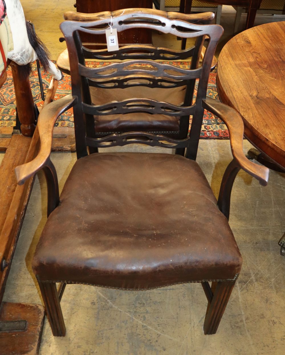 A pair of George III mahogany pierced ladderback elbow chairs
